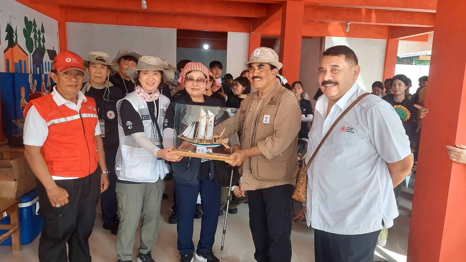 Pengurus Pusat PMI Marsekal Muda TNI (Purn) Tri Bowo Budi Santoso menyerahkan cendera mata berupa miniatur kapal layar ke perwakilan Palang Merah Korea dalam kunjungan hari ke-tiga di Pulau Untung Jawa, Jumat (21/2/2025).