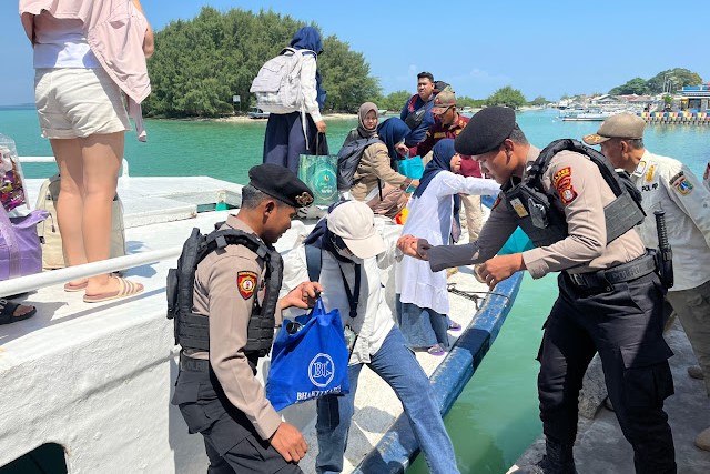 Anggota Polisi Membantu Penumpang Kapal di Pulau Kelapa. 📷 Istimewa