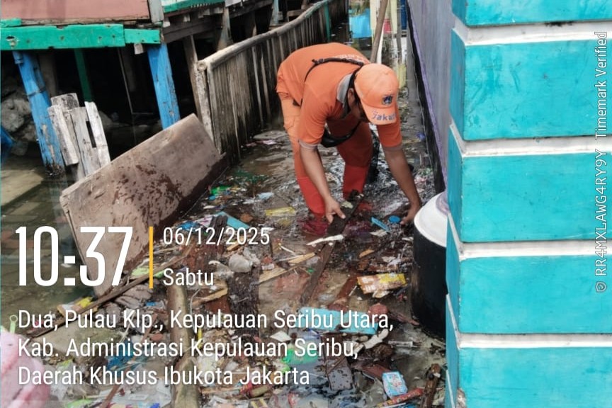 📸 Anggota PPSU Kelurahan Pulau Kelapa dengan gigih membersihkan sisa-sampah yang terbawa arus banjir rob. Mereka berjuang mengembalikan kebersihan lingkungan dari limbah yang meluap dari saluran IPAL.