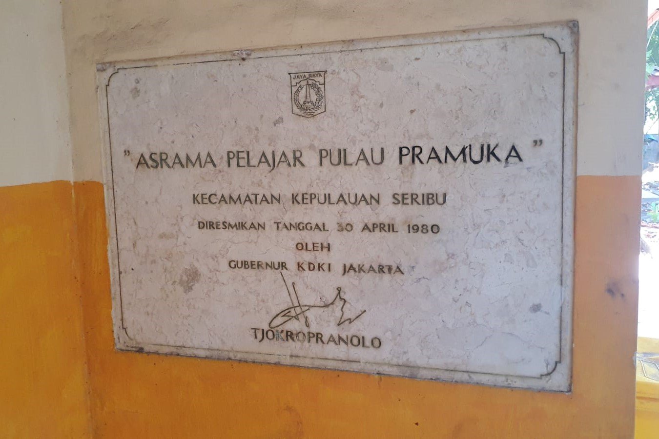 Prasasti peresmian gedung Asrama Pelajar Pulau Pramuka yang ditandatangani langsung oleh Gubernur KDKI Jakarta, Tjokropranolo, tertanggal 30 April 1980. Bukti sejarah ini menegaskan usia pakai bangunan yang telah melampaui 46 tahun dan kini dinantikan realisasi rencana rehabilitasi totalnya oleh masyarakat pulau. (Foto: Tim Redaksi)