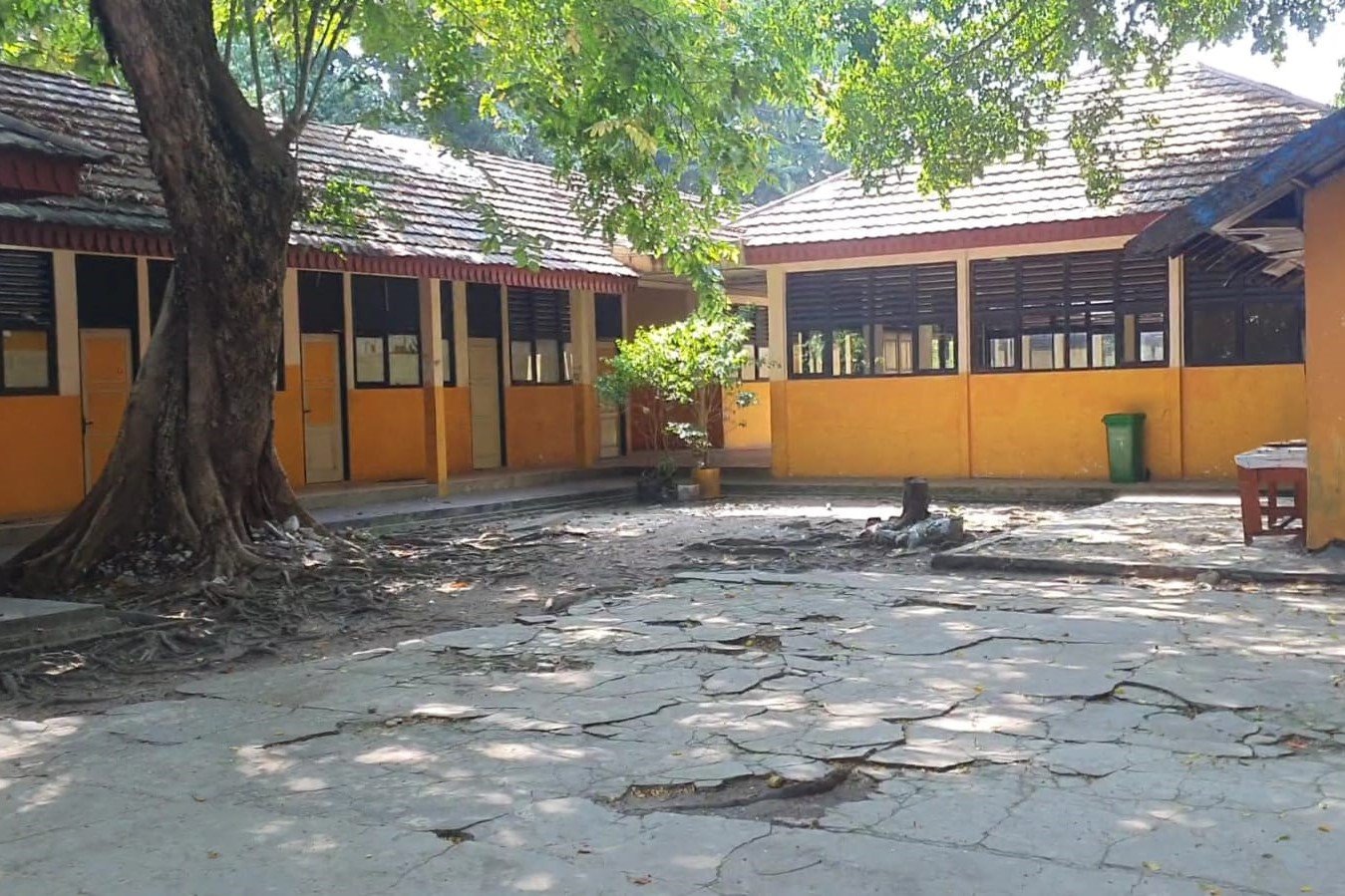 Kondisi area pekarangan dan fasad bangunan Asrama Pelajar Putra Pulau Pramuka yang menunjukkan tanda-tanda penurunan kualitas di beberapa bagian. Lantai semen di halaman tampak retak-retak dan bergelombang akibat termakan usia sejak pertama kali difungsikan. (Foto: Tim Redaksi)
