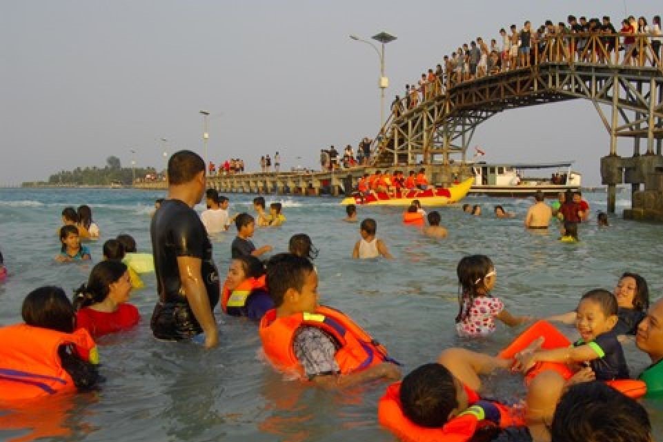 Antusiasme wisatawan saat berenang dan menikmati panorama sore di sekitar ikon Jembatan Cinta, Pulau Tidung. (Foto: Istimewa)