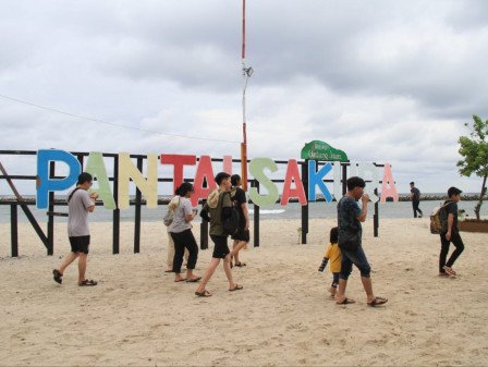 Sejumlah pelancong berjalan santai menikmati keindahan panorama pesisir di Pantai Sakura, Pulau Untung Jawa. (Foto: Istimewa)