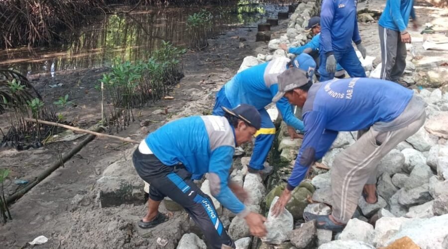 Pekerja Sudin SDA Kepulauan Seribu memperbaiki tanggul di pesisir Pulau Pramuka.
