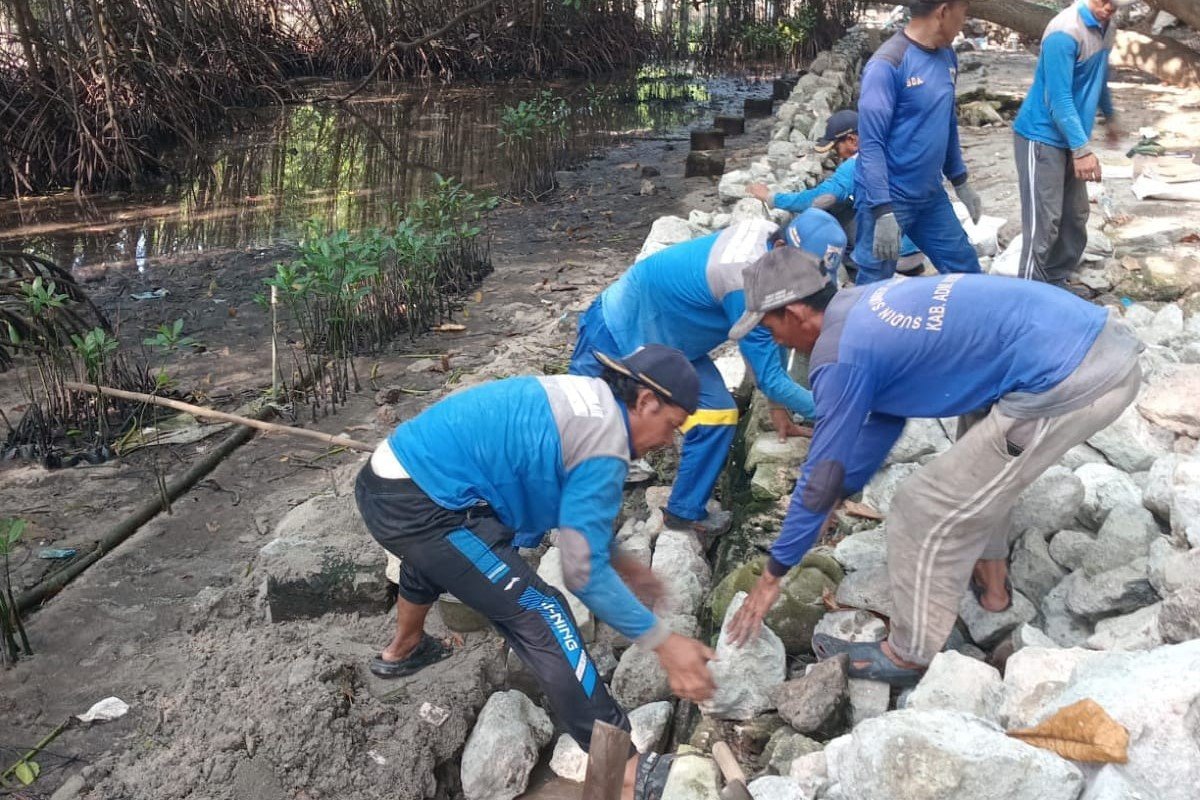 Pekerja Sudin SDA Kepulauan Seribu memperbaiki tanggul di pesisir Pulau Pramuka.