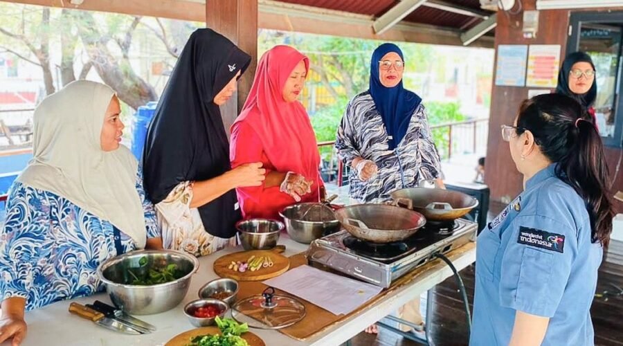 Warga dan ibu rumah tangga di Pulau Kelapa memegang spatula mengaduk masakan Ayam Bumbu Woku di wajan