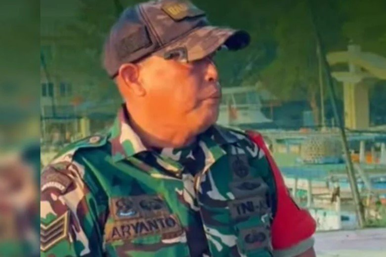 Anggota Babinsa Kodam Jaya Serka Aryanto mengumpulkan sampah plastik di pesisir pantai Kepulauan Seribu