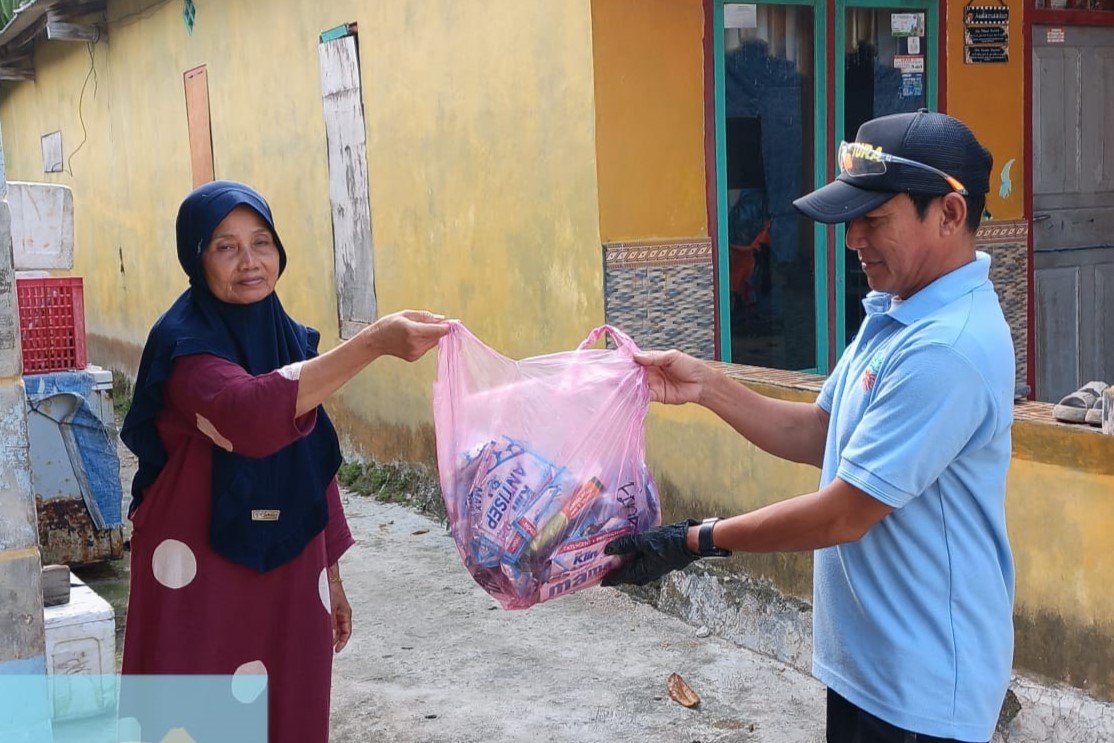 PJLP Sudin Lingkungan Hidup Kepulauan Seribu, Agung, menyerahkan kantong pemilahan sampah kepada warga Pulau Sabira saat sosialisasi door to door guna meningkatkan partisipasi masyarakat dalam Gerakan Pilah Sampah dari Sumber. Foto: Agung