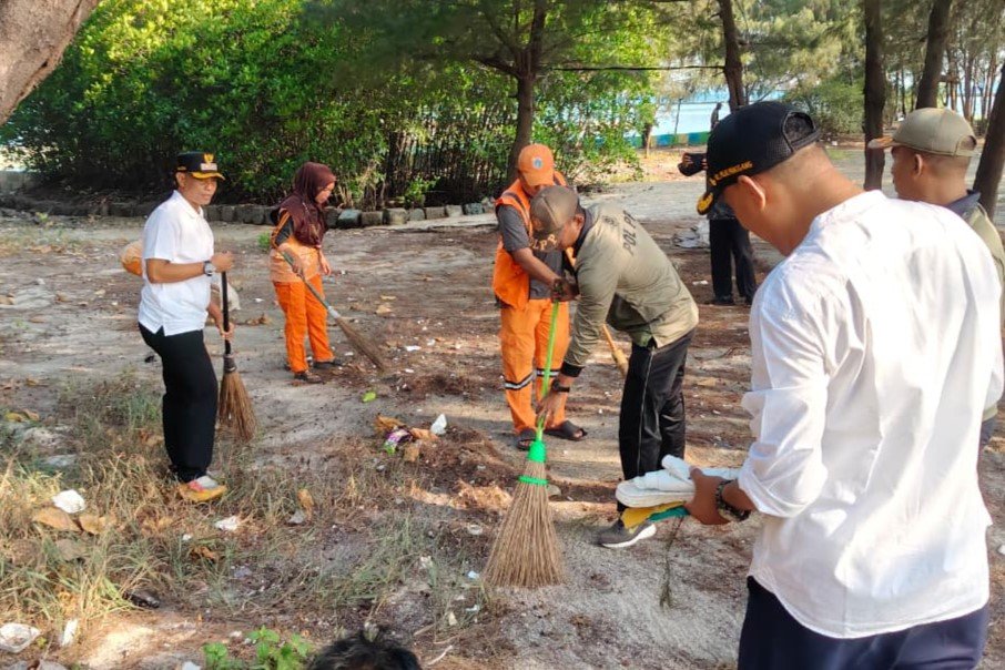 Personel gabungan membersihkan kawasan Pantai Cikaya di Pulau Karya dalam kegiatan kerja bakti serentak untuk memperindah kawasan wisata.
