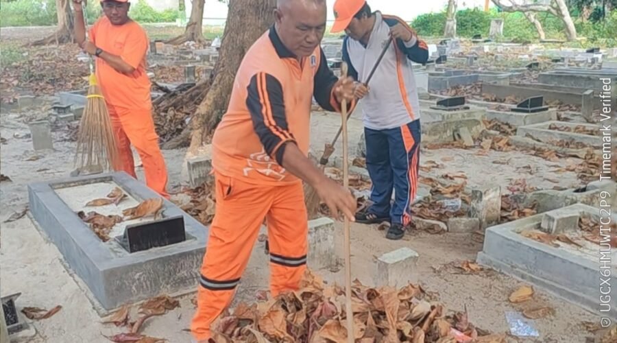 Personel PPSU Kelurahan Pulau Kelapa bersama PJLP Sudin Lingkungan Hidup membersihkan area pemakaman di Pulau Kelapa.