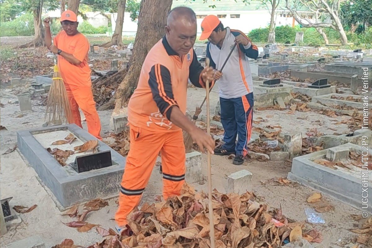 Personel PPSU Kelurahan Pulau Kelapa bersama PJLP Sudin Lingkungan Hidup membersihkan area pemakaman di Pulau Kelapa.