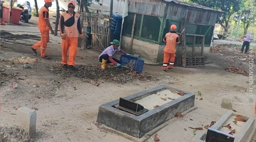 Petugas PPSU mengumpulkan daun kering saat membersihkan kawasan pemakaman Pulau Kelapa.