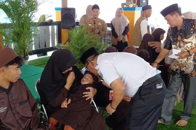 Warga Pulau Untung Jawa menyerahkan santunan kepada anak yatim dalam kegiatan berbagi rezeki.
