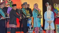 Bupati Kepulauan Seribu menyerahkan penghargaan kepada Bang Reza dan Non Nadya sebagai Abang dan None Kepulauan Seribu 2026.
