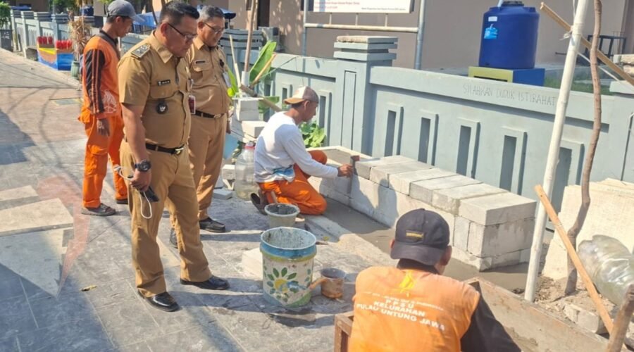 Lurah Pulau Untung Jawa meninjau pembangunan bangku bermural di jalan utama pulau.