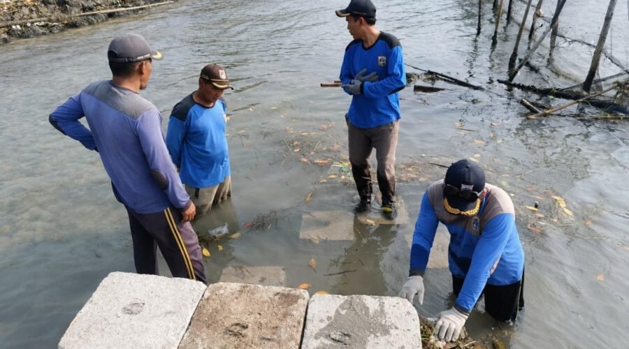 Pasukan Biru Sudin SDA memperbaiki tanggul kubus masif di Pulau Lancang.