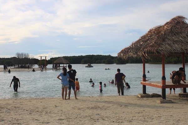 Wisatawan menikmati suasana Pantai Pasir Perawan di Pulau Pari, Kepulauan Seribu, saat akhir masa libur sekolah.